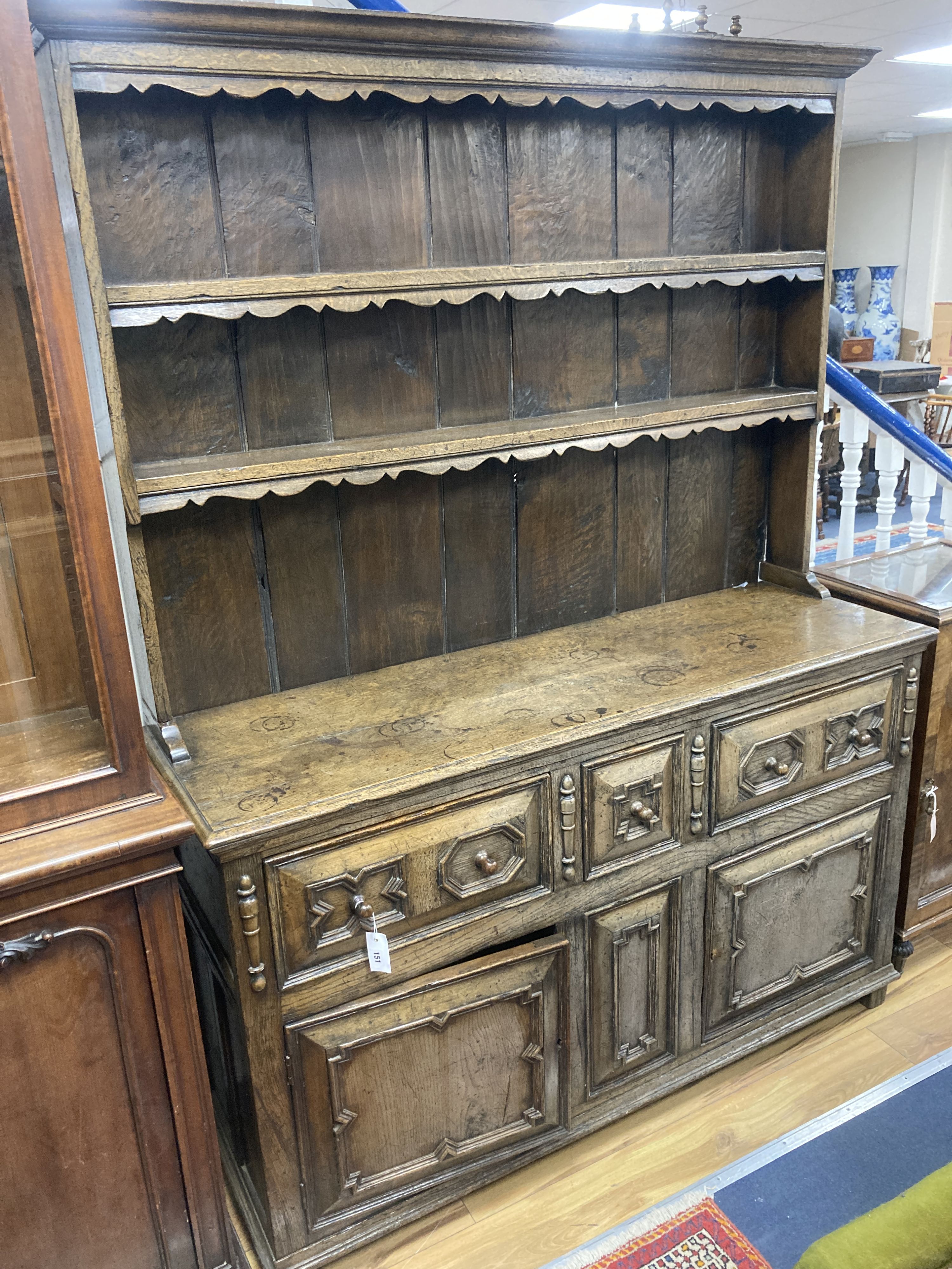 An early 20th century Jacobean style oak dresser, width 150cm, depth 47cm, height 199cm